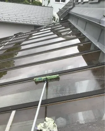 Reinigung eines Glasdachs mit Einwascher und Teleskopstange
